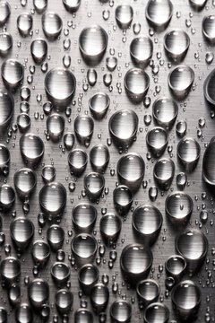 Abstract background with drops of water on metal flat surface