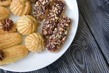 Homemade eclairs with cream. They lie on a plate. Custard pastries with cream. Close-up.