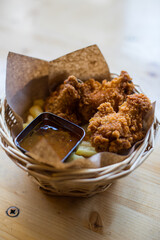 Chicken wings in a basket, with French fries and sauce