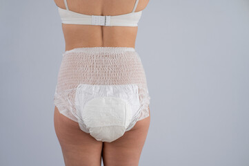 Rear view of a woman in adult diapers. Incontinence problem.