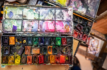 Watercolor paints started an open box at the artist's workplace.