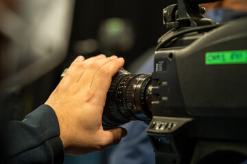 Hand correcting the focus on a broadcast tv camera