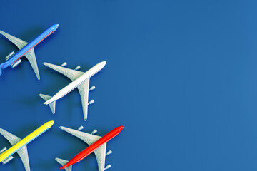 Toy models of passenger planes on a blue background. Simulation of flight in the sky. Concept of choosing an air ticket, spotting, relocation or air travel. Diagonal. Copy space