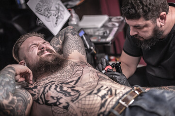 Fototapeta na wymiar Tattoo specialist and his customer in the workshop