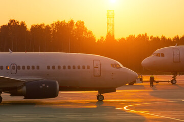 Two planes at sunset face each other, departure and arrival.