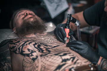 Tattooer makes cool tattoo in the salon