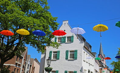 Festival day in  medieval historic lower rhine village with church, old houses, blue summer sky,...