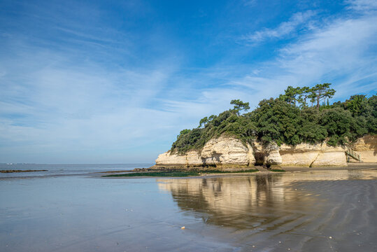 Sea cliffs reflection on wet sandy beach Gironde estuary, Charente-Maritime on Atlantic coast France