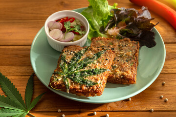 Dish of hot delicious cannabis deep fried minced pork toast menu with sweet and sour sauce on wooden table background. Eatable food decoration recipe local international food herb for concept ideas