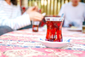 Traditional Turkish tea. Bardak - a glass in the shape of a tulip. Excellent delicious breakfast on the coast. Unforgettable view in Turkey. Strong sweet tea is a landmark of Turkey and Istanbul