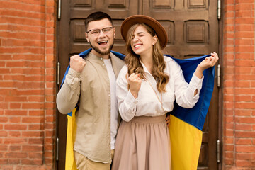 Emotional screaming couple hugging with the flag of Ukraine. Ukraine love concept. Freedom of...