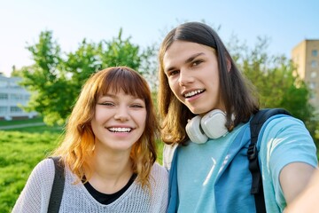 Obraz premium Young teenage friends guy and girl having fun, laughing, taking selfie photo