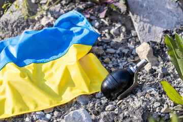 Ukrainian flag and a grenade lying among rubble and ruins, Concept of aggression and war in Ukraine