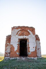 The entrance to the old building, the ancient temple is destroyed, the front door is missing, the roof was demolished, the church ruins against the sky, the abandoned building.