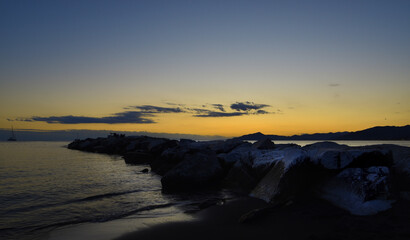 incredible colors and lights, a romantic sunset on the beach facing the sea in the magnificent Liguria