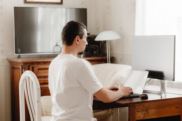 A man at a table with correct posture sits at a computer