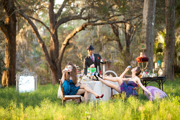 High Fashion Models posing around Alice in Wonderland Inspired Mad Hatter table having drinking tea