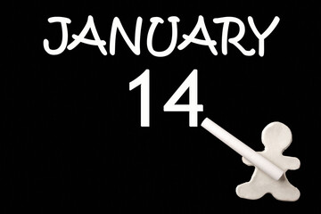 A small white plasticine man writing the date 14 January on a black board. Business concept. Education concept.