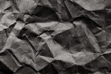 Background from crumpled black paper. Dark paper with folds, scuffs and waves