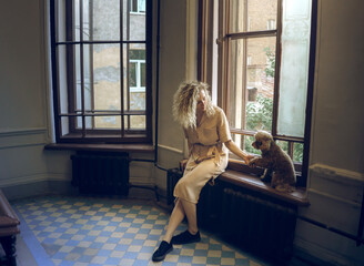girl and two dogs in the city stairwell inside for a walk. Little poodle outdoors