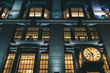 Low angle of retro building with a clock at night - Powered by Adobe