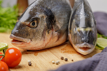 Fresh dorado fish, on a wooden board, two heads close-up