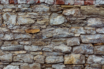Old stone wall with peeling off plaste