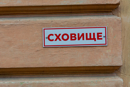 A plate on the wall of a house with the inscription SHELTER in a Ukrainian city