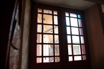 Photo inside the corridor of an old apartment building, the sun shines through the windows and front door