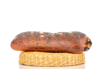 One appetizing homemade poppy seed roll on a straw stand, close-up, isolated on a white background.