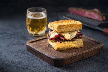 Sandwich with beef pastrami on wooden board