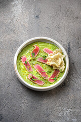 Restaurant dish: fresh tuna tartar on avocado puree op view