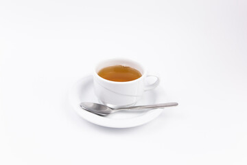 white porcelain cup with tea for tomorrow on the table with a saucer