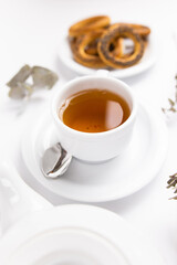 white porcelain cup with tea for tomorrow on the table with a saucer