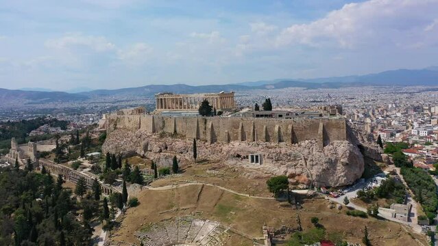 Aerial drone video of iconic Acropolis hill featuring masterpiece theatre of Dionysus and the Parthenon, Athens historic centre, Attica, Greece