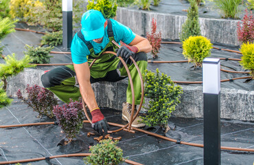Professional Landscaper Building Drip Irrigation System in a Garden