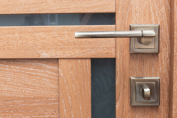 copper handle on the wooden door. close-up