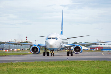 Passenger aircraft taxiing on the apron of the airport on the asphalt is visible marking.