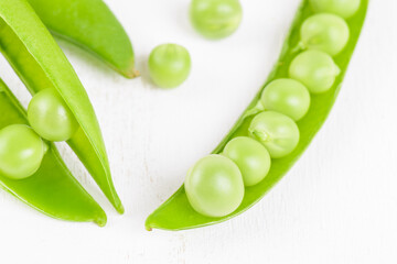 Fresh organic raw green opened peas pod on white background. Healthy eating, vegan and vegetarian legume food, raw food and detox super food, bean protein, close up
