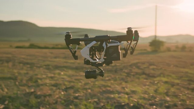 Professional copter drone flight in agricultural wide field. Quadcopter controls harvest condition and soil. Innovations for farming business.