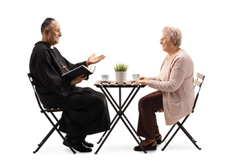 Priest in a cafe sitting and talking to an elderly woman