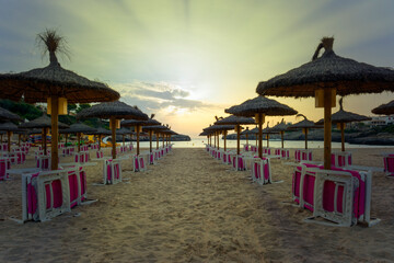 cala marsal beach, beaches of mallorca, spain, with rows of umbrellas and hammocks, ready for tourists,vacation tourism concept