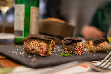 Italian cuisine - caprese with black truffle on a black slate stone in the evening on a table in a restaurant, close-up, selective focus
