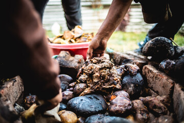 Elaboración de Pachamanca en horno de piedras. Comida tradicional del Perú