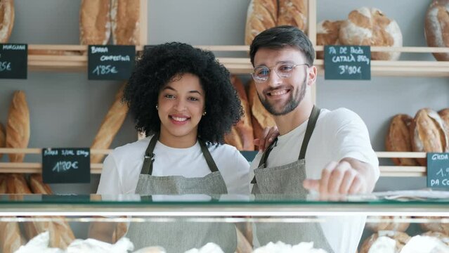 Video of two younger owners selling fresh pastry and loaves un bread section and smiling at pastry shop.