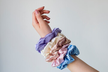 Silk elastic bands on woman's arm. Luxury colors.