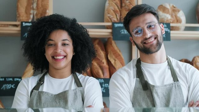 Video of two younger owners selling fresh pastry and loaves un bread section and smiling at pastry shop.