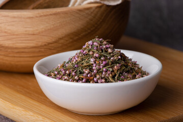 A mound of pink heather in a bowl.
Dry heather spice. Heather flower.