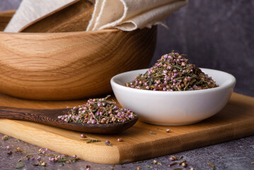 A mound of pink heather in a bowl.
Dry heather spice. Heather flower.