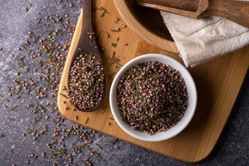 A mound of pink heather in a bowl.
Dry heather spice. Heather flower.